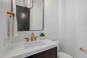 Half bathroom featuring vanity and toilet