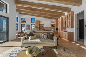 Living area featuring beam ceiling, light wood finished floors, and high vaulted ceiling