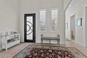Entrance foyer featuring light tile patterned floors and baseboards