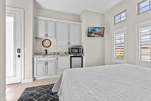 Bedroom featuring stainless steel fridge and light tile patterned flooring