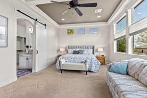 Bedroom featuring a barn door, multiple windows, carpet floors, a raised ceiling, and recessed lighting