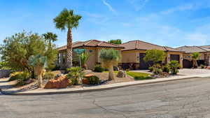 Mediterranean / spanish-style home featuring stucco siding, an attached garage, driveway, and a tiled roof
