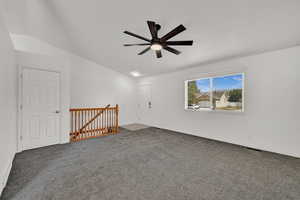 Family room with gray colored carpet, a ceiling fan, and vaulted ceiling