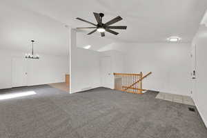 Family room with gray colored carpet, a ceiling fan, and vaulted ceiling