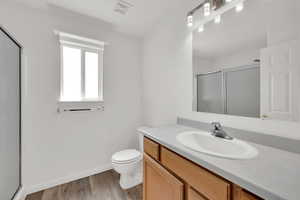 3/4 bathroom featuring vanity, a stall shower, and LVP flooring