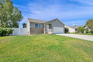 Ranch-style home with driveway, a garage, brick siding, and stucco siding