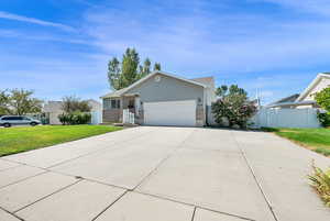 Ranch-style house with concrete driveway, brick siding, an attached garage, and stucco siding