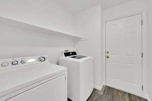 Laundry area with LVP floors and washing machine and clothes dryer