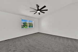 Family room with gray colored carpet, a ceiling fan, and vaulted ceiling