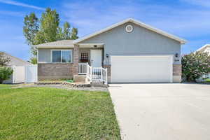 Ranch-style house featuring driveway, stucco siding, an attached garage, and brick siding
