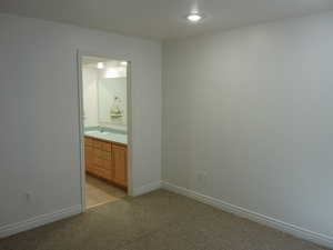 Unfurnished bedroom featuring light colored carpet, recessed lighting, and ensuite bathroom