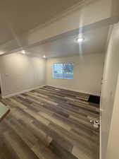 Basement featuring dark wood-type flooring, a textured ceiling, crown molding, and recessed lighting