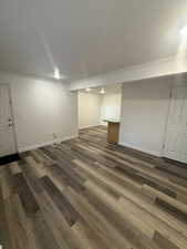Finished below grade area with crown molding and dark wood-style floors