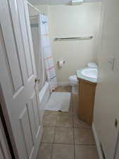 Bathroom featuring light tile patterned flooring, vanity, and shower / bath combo with shower curtain