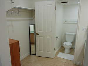 Bathroom featuring toilet and light tile patterned flooring