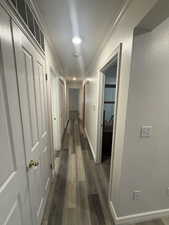 Hall with dark wood-style floors and crown molding