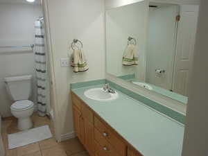 Full bathroom with light tile patterned floors, vanity, and shower / tub combo
