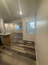 Spare room with crown molding, dark wood finished floors, and a textured ceiling