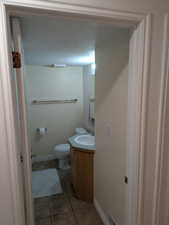 Bathroom featuring light tile patterned flooring, vanity, and a textured ceiling