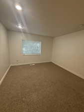 Carpeted spare room with baseboards and a textured ceiling