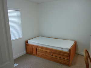 Bedroom featuring baseboards and light carpet