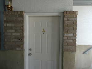 Entrance to property featuring brick siding and stucco siding