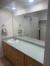 Bathroom with vanity, light tile patterned floors, and a textured ceiling