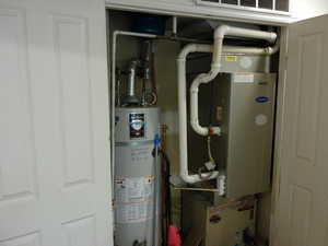 Utility room featuring secured water heater and heating unit