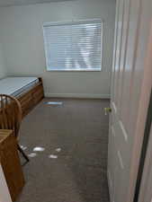 Bedroom featuring carpet and baseboards