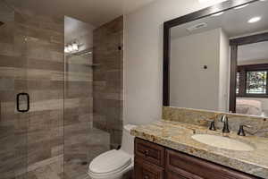 Full bath featuring ensuite bath, a stall shower, and vanity