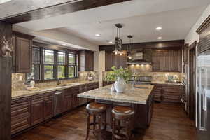 Kitchen featuring pendant lighting, dark wood-type flooring, decorative backsplash, recessed lighting, and dark brown cabinetry