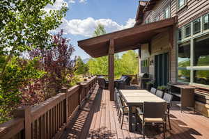 Wooden deck with outdoor dining space and area for grilling