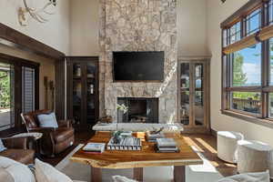 Living area with a fireplace, a high ceiling, and wood finished floors