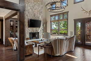 Living area with a fireplace, hardwood / wood-style floors, and a towering ceiling