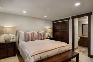 Bedroom featuring recessed lighting, light carpet, ensuite bathroom, and a closet