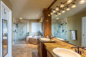 Bathroom with a stall shower, double vanity, and a garden tub
