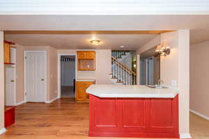 Kitchen featuring a peninsula, tile countertops, and light wood-style floors