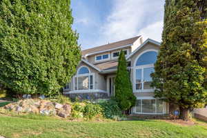 View of front of home featuring stucco siding, a front yard, and roof with shingles