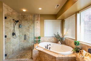 Full bathroom featuring a shower stall, a bath, and recessed lighting
