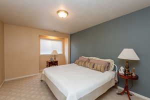 Bedroom featuring a textured ceiling and light carpet