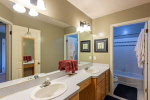 Bathroom featuring double vanity, bathtub / shower combination, and tile patterned flooring