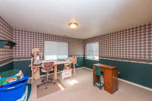 Home office with carpet flooring and a textured ceiling