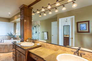 Bathroom featuring a stall shower, a bath, and double vanity