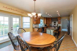 Dining room featuring light flooring, a chandelier, recessed lighting, and french doors