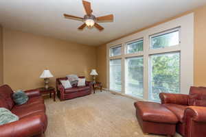 Living room featuring carpet and ceiling fan