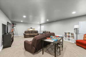 Living area with light colored carpet and recessed lighting