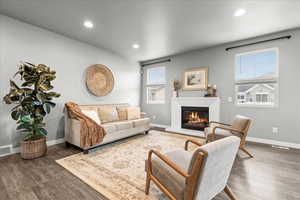 Living area featuring recessed lighting, a glass covered fireplace, and wood finished floors