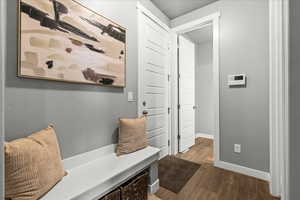Mudroom featuring dark wood-style flooring and baseboards