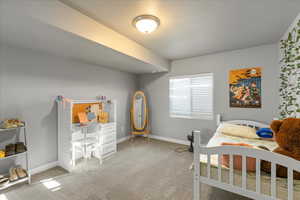 Bedroom with light colored carpet and baseboards