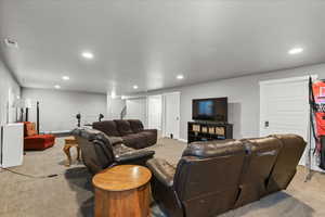 Living area with light colored carpet and recessed lighting
